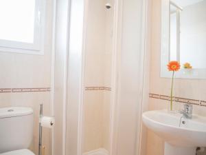 a white bathroom with a toilet and a sink at Apartamentos Doña Maria in Alcossebre +10 photos