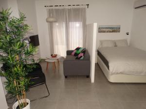 ein Schlafzimmer mit einem Bett, einem Sofa und einem Stuhl in der Unterkunft Málaga Apartamentos - Jinetes, 23 in Málaga