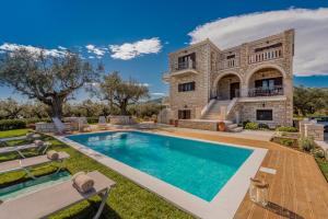 an estate with a swimming pool in front of a house at Filoxenia Stone House in Kalpaki