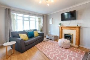 a living room with a couch and a fireplace at Pleasant Stay in Swansea - TV in Every Bedroom! in Swansea