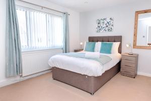 Un dormitorio con una cama grande y una ventana. en Contractor Stay - Parking - En-suites - TVs, en Swansea