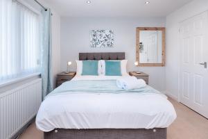a bedroom with a large bed with two towels on it at Pleasant Stay in Swansea - TV in Every Bedroom! in Swansea