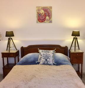 a bedroom with a bed with two end tables and two lamps at LApartment du Perigord in Javerlhac-et-la-Chapelle-Saint-Robert