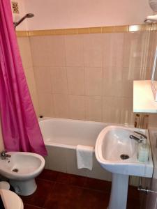 ein Badezimmer mit einer Badewanne, einem Waschbecken und einem WC in der Unterkunft House located in opposite of beach! in Lagoa