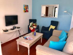 ein Wohnzimmer mit einem Sofa und einem Tisch in der Unterkunft House located in opposite of beach! in Lagoa