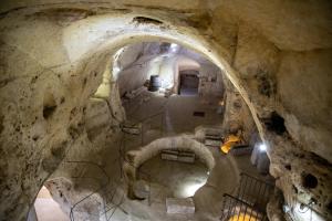 a tunnel in a cave with a stone wall at Hotel San Giorgio in Matera