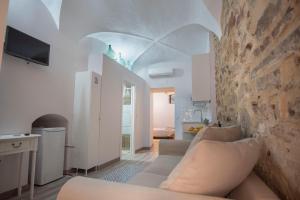 sala de estar con sofá y pared de piedra en Apartamento nuevo Casco Antiguo AT Postigo 20, en Cáceres