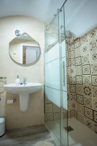 y baño con lavabo y ducha acristalada. en Apartamento nuevo Casco Antiguo AT Postigo 20, en Cáceres