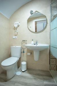 y baño con aseo, lavabo y espejo. en Apartamento nuevo Casco Antiguo AT Postigo 20, en Cáceres