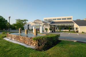 a building with a stone wall in front of a building at Holiday Inn Cape Cod - Hyannis by IHG in Hyannis