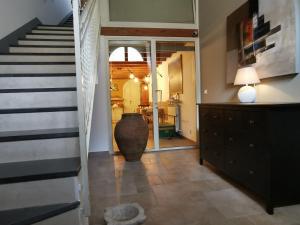 a hallway with a staircase and a large vase on the floor at B&B Re Umberto in Milazzo