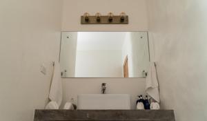 a bathroom with a mirror and a sink at Hotel Nya in Montezuma