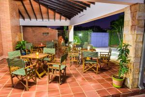 an outdoor patio with wooden tables and chairs at Palmera Hotel CDE in Ciudad del Este
