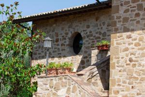 a stone building with a window and a street light at Santa Maria Degli Ancillotti in Petrignano