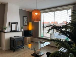 a living room with a glass table and a fireplace at Texelheerlijk 4 in De Koog