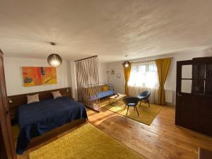 a bedroom with a bed and a desk and a chair at SIM House & Barn in Săcele