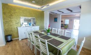 jadalnia ze stołem, krzesłami i lustrem w obiekcie Villa VAND Paradiso w Medziugorie