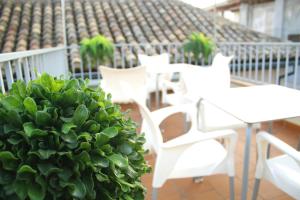 a group of white tables and chairs on a balcony at Laurel Suites Apartments in Granada