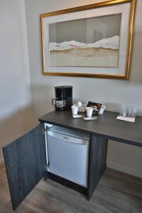 a table with a coffee maker and cups on it at Motel Castille in Roberval