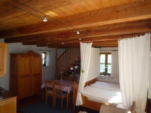 Un dormitorio con una cama y un comedor con una mesa. en Ferienbauernhof Bosch, en Fünfstetten