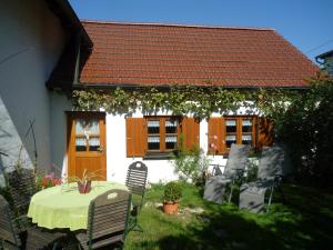 Una mesa y sillas frente a una casa en Ferienbauernhof Bosch, en Fünfstetten