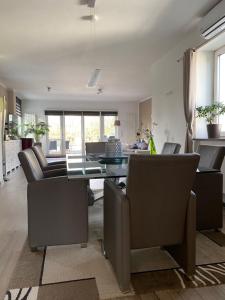 - un salon avec une table et des fauteuils en cuir dans l'établissement Stadtvilla Intzeplatz - Apartment Sylt, à Remscheid