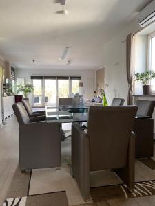 a living room with a table and leather chairs at Stadtvilla Intzeplatz - Apartment Sylt in Remscheid