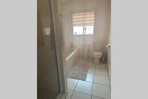 a bathroom with a tub and a toilet and a sink at Phantom view in Alberton