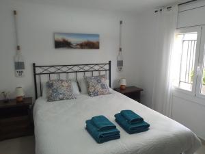 a bedroom with a bed with two towels on it at Sunny Holiday Home in Creixell