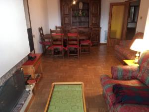 a living room with a couch and a table and chairs at Apartamentos 7 Valles Jaca Centro in Jaca
