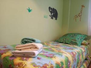 a childs bedroom with a bed with a giraffe and towels at Apartamentos 7 Valles Jaca Centro in Jaca