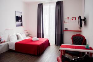 1 dormitorio con cama roja y silla roja en Relais Cola Di Rienzo, en Roma