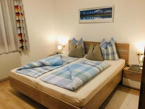ノイシュティフト・イム・シュトゥーバイタールにあるHaus Jenewein Manfredのベッドルーム1室(青と白の枕が備わるベッド1台付)