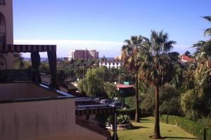 Blick auf die Stadt von einem Gebäude mit Palmen in der Unterkunft Apartamento Bellasol in Mijas