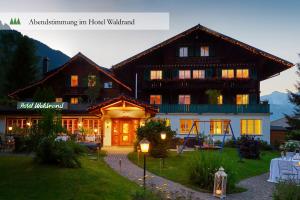 a large building in front of a building at Hotel Waldrand in Lenk