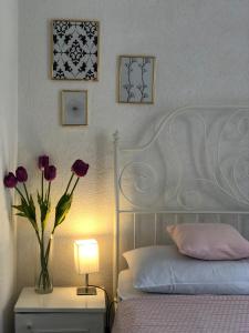 a bedroom with a bed and a vase of flowers on a night stand at Vila Luka in Slano