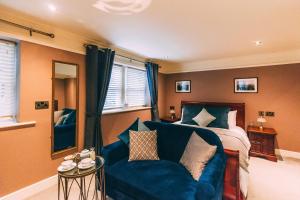 - une chambre avec un lit et un canapé bleu dans l'établissement Weavers Guesthouse by Weavers of Haworth, à Haworth