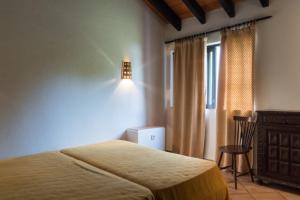 een slaapkamer met een bed, een lamp en een raam bij Pedras Del Rei II in Tavira