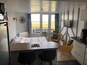 ドーヴィルにあるAu petit port de Deauville - studio avec vue merのベッド、テーブル、椅子が備わる小さな客室です。