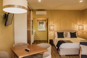 
a hotel room with a bed, table and chairs at Hotel Neptuno in Peniche

