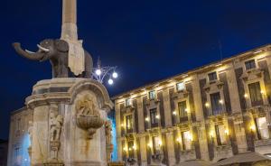 a statue in front of a building at night at Le Suites Del Duomo in Catania