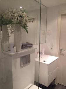 a bathroom with a sink and a vase of flowers at Bed and Breakfast Valckenbosch in Zeist