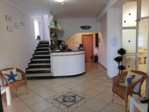 a living room with a staircase and some chairs at Hotel La Bella Vita in Rimini