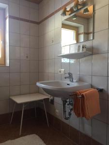 a bathroom with a sink and a mirror and a stool at Mitterbergerhof in Wiesen