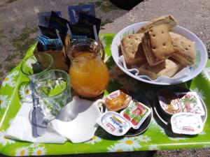 a tray of food with bread and a bowl of orange juice at Hospedaje Iruya Mi Pueblo in Iruya