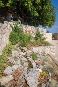 un jardín con rocas y una pared de piedra en Villa Perka, en Sveta Nedelja