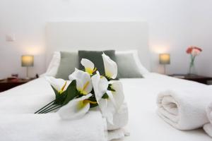 a white bed with a bouquet of white flowers on it at Corral del Conde in Seville