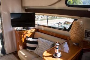 a table with a lamp and a television on a boat at AQUADOURO Yacht RADAMES - Sleep Boat Experience in Castelo de Paiva
