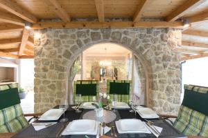 a stone walled dining room with a table and chairs at Villa Diamond - Muraj Krk in Kornić