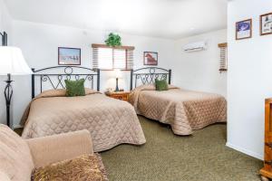 1 dormitorio con 2 camas y sofá en Larian Motel, en Tombstone